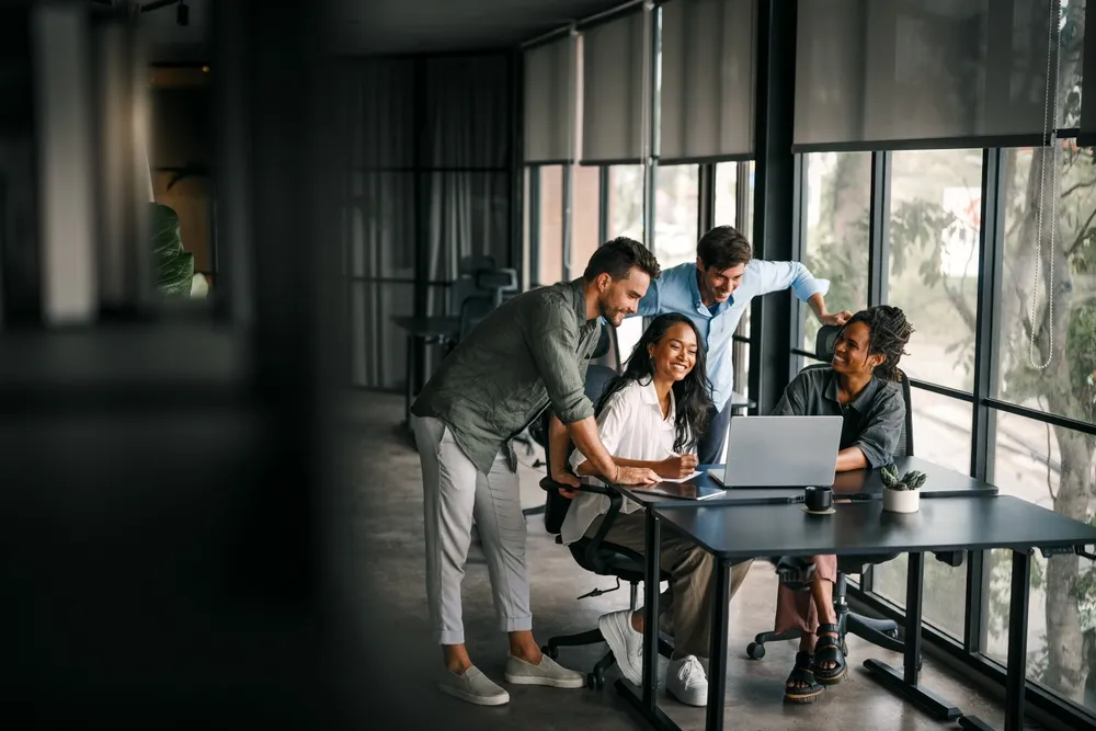 Small team reviewing figures on a laptop in a meeting room