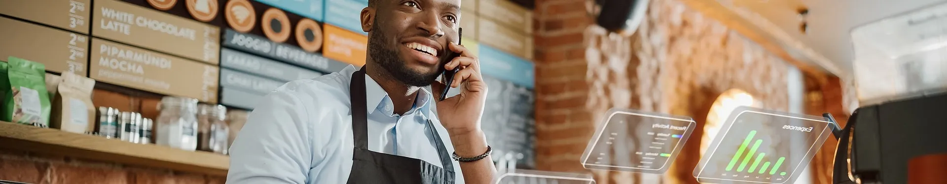 Barista taking an order by phone at a coffee shop counter