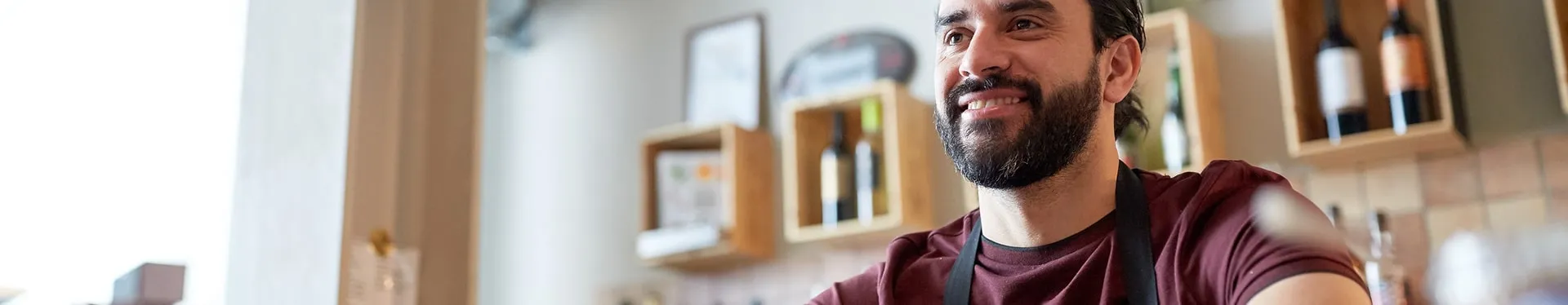 Shop owner smiling behind the counter of his store